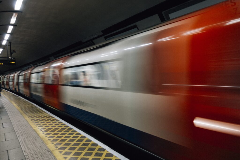 Tren de metro en marcha junto al andén de una estación