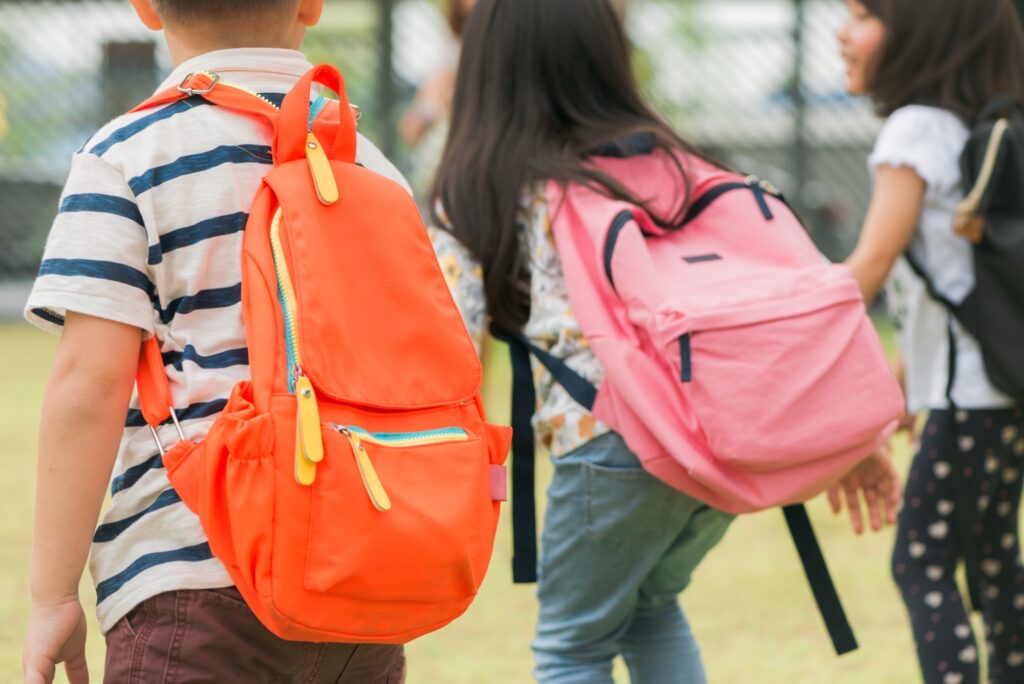 Niños con mochilas de camino al colegio